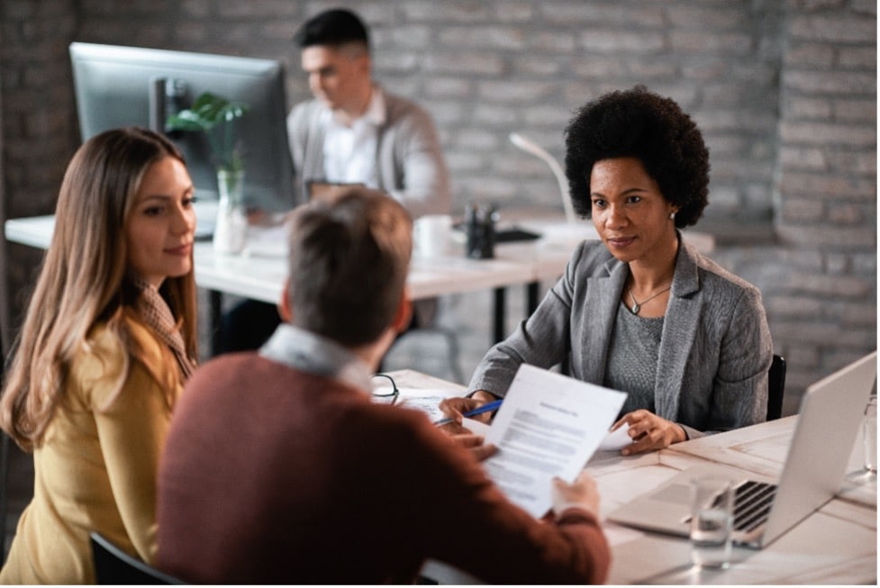 African American financial advisor meeting with her clients at her office
