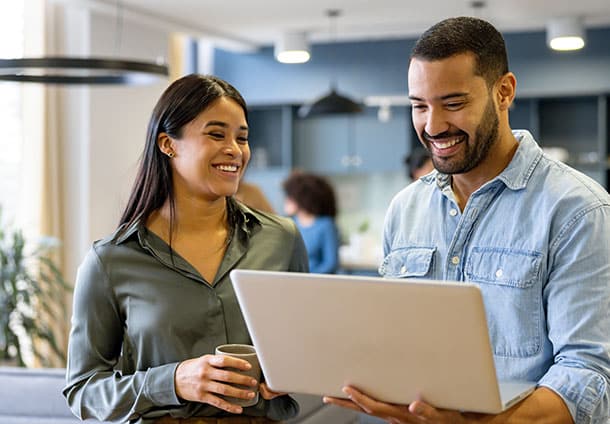 Two office workers looking at a laptop