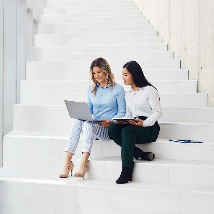 Two female professionals discussing work