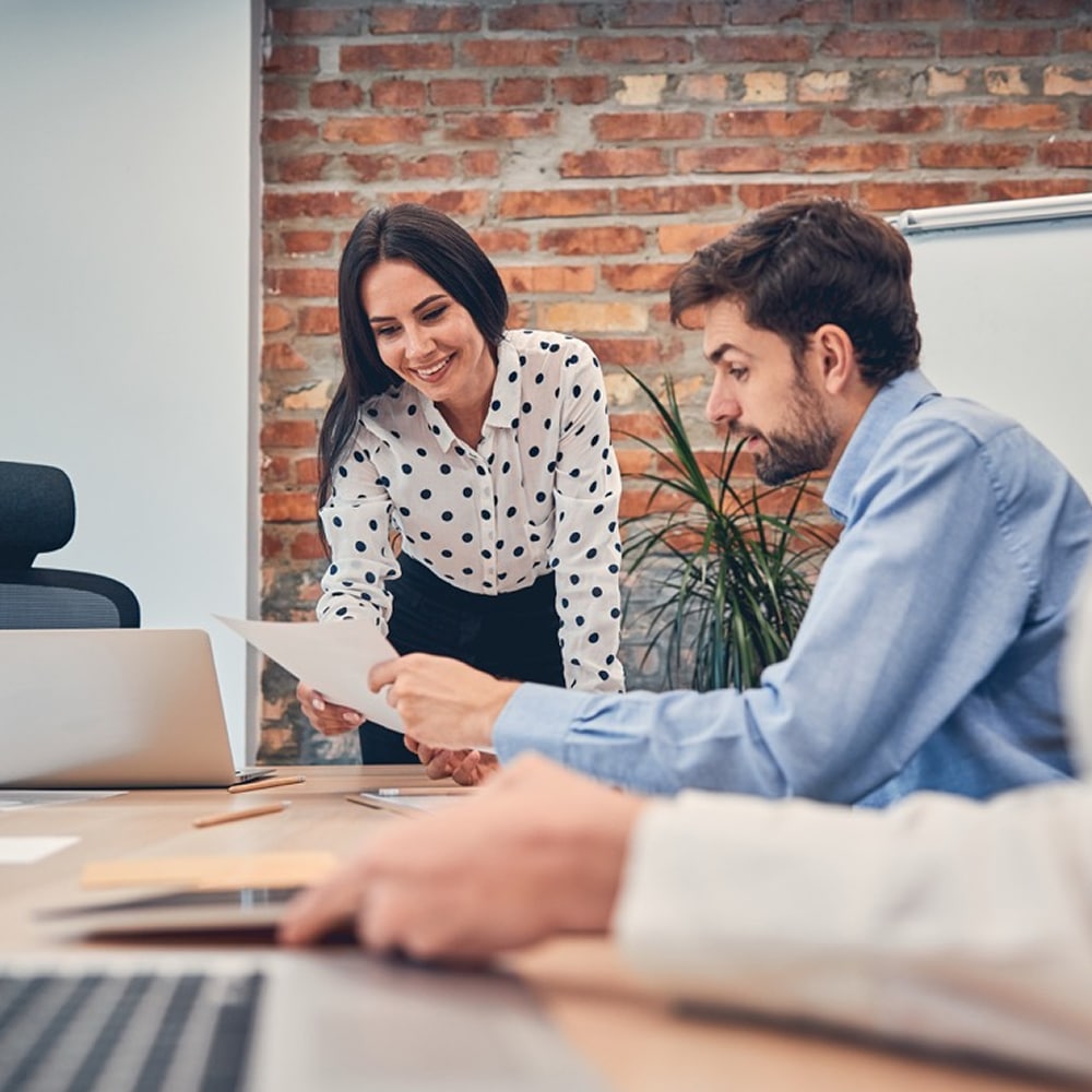 Two coworkers reviewing a document together
