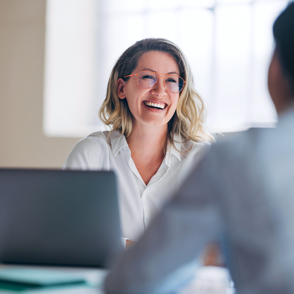 Person smiling during a conversation in an office