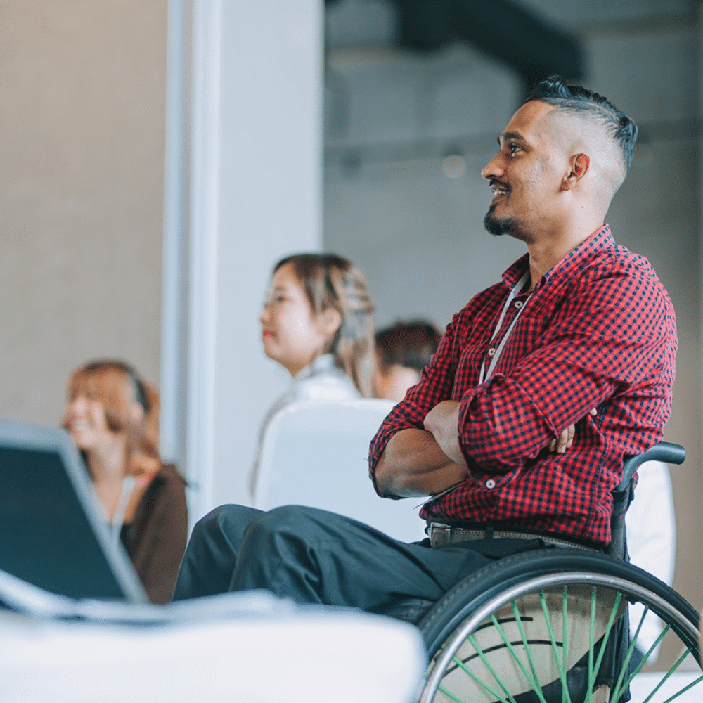 Person seated in a wheelchair during a meeting