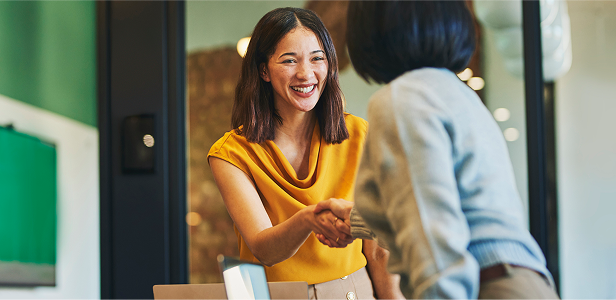A female hotel clerk greeting a customer.
