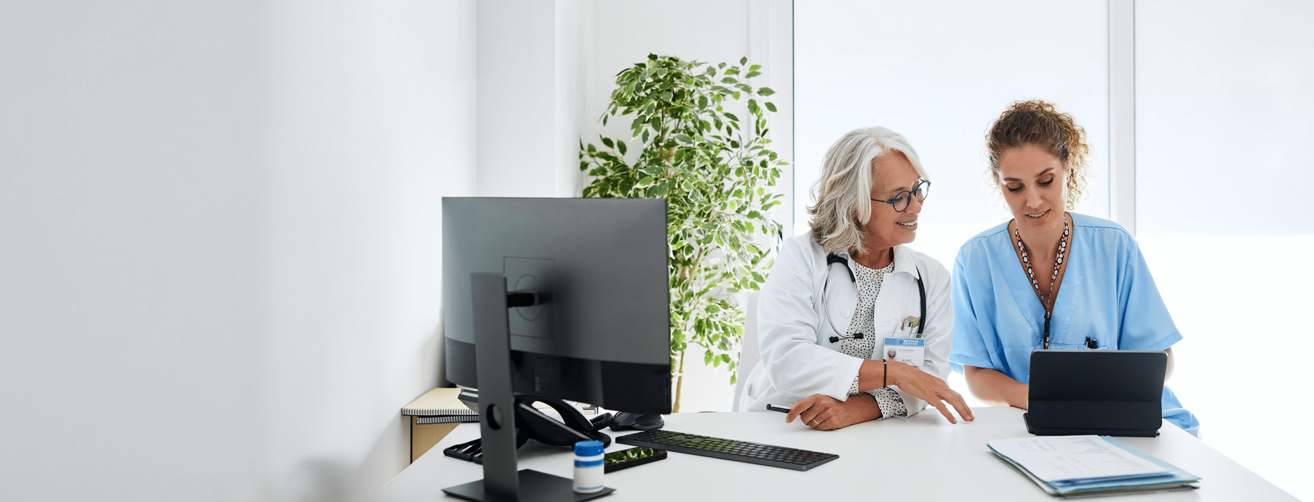 Healthcare professionals reviewing information on a tablet.