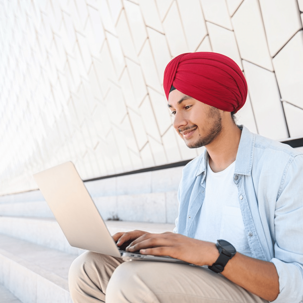 Person using a laptop while sitting outdoors on steps