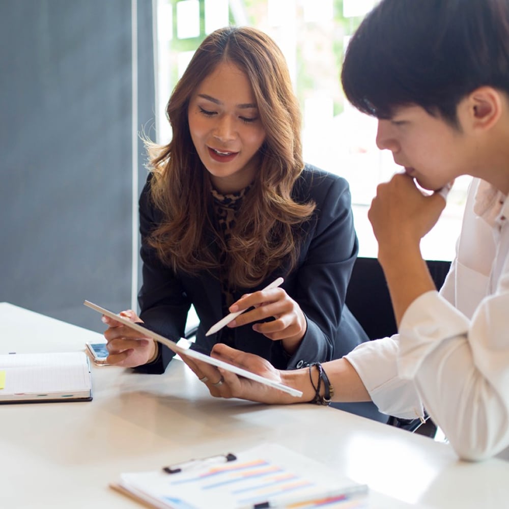 Two coworkers reviewing a document.