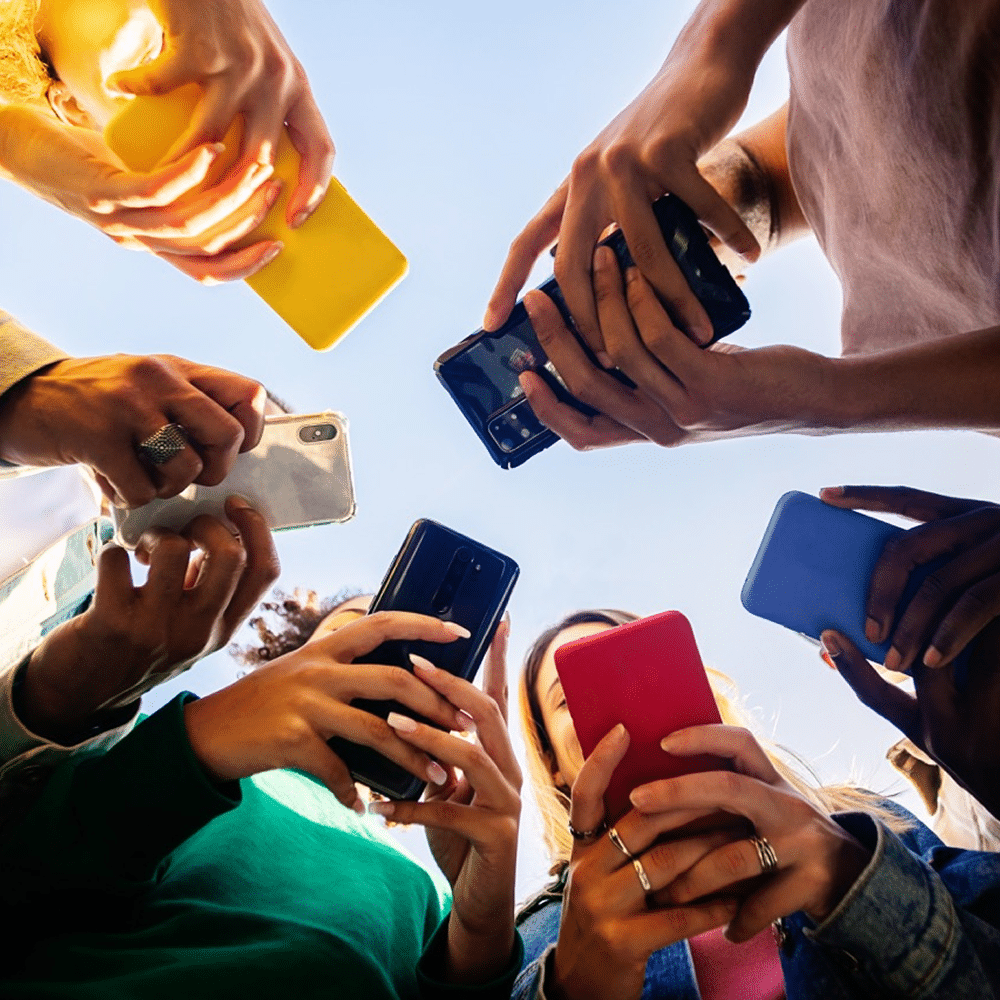 Multiple people checking phones outside