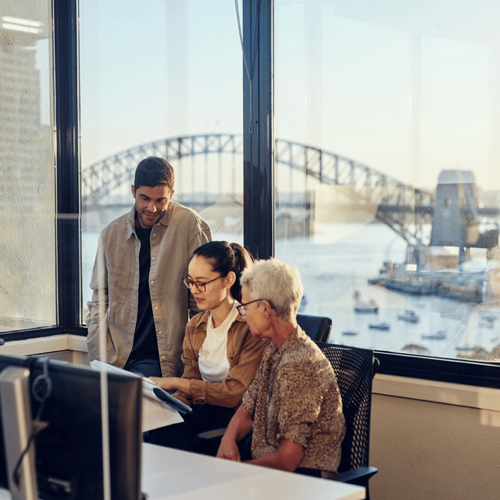 Team collaborating in office with harbor view