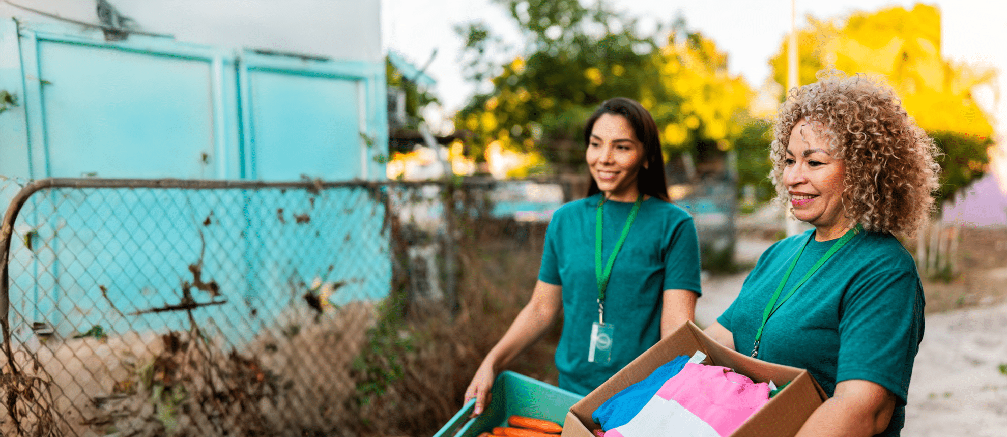 Two volunteers carrying a box of clothes.