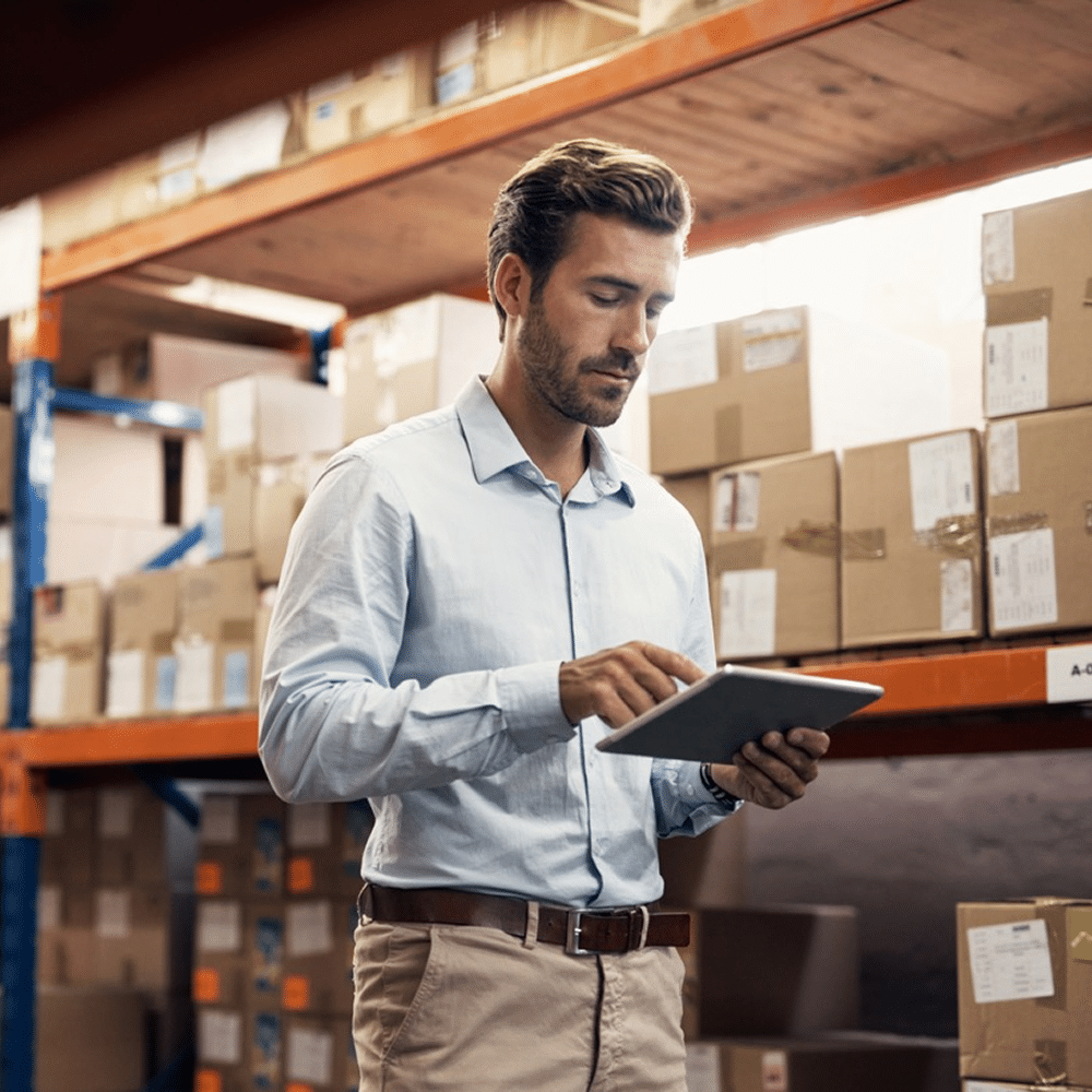 Warehouse staff reviewing items on digital tablet.