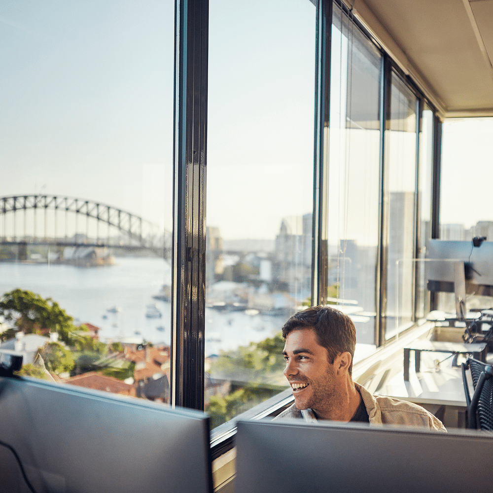 A male smiling looking at his screen.