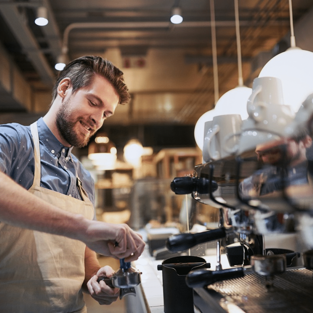 Barista making coffee with an espresso machine.