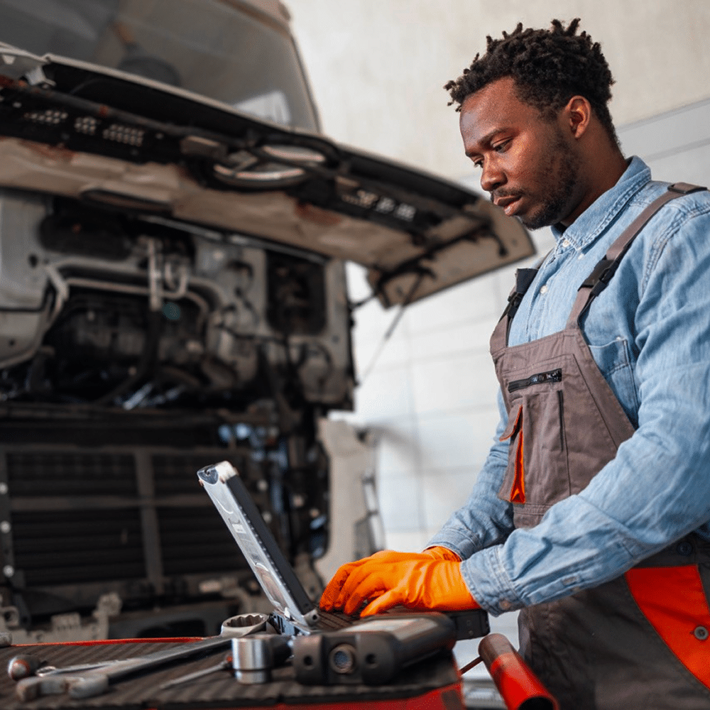 Mechanic using a laptop to diagnose a truck engine