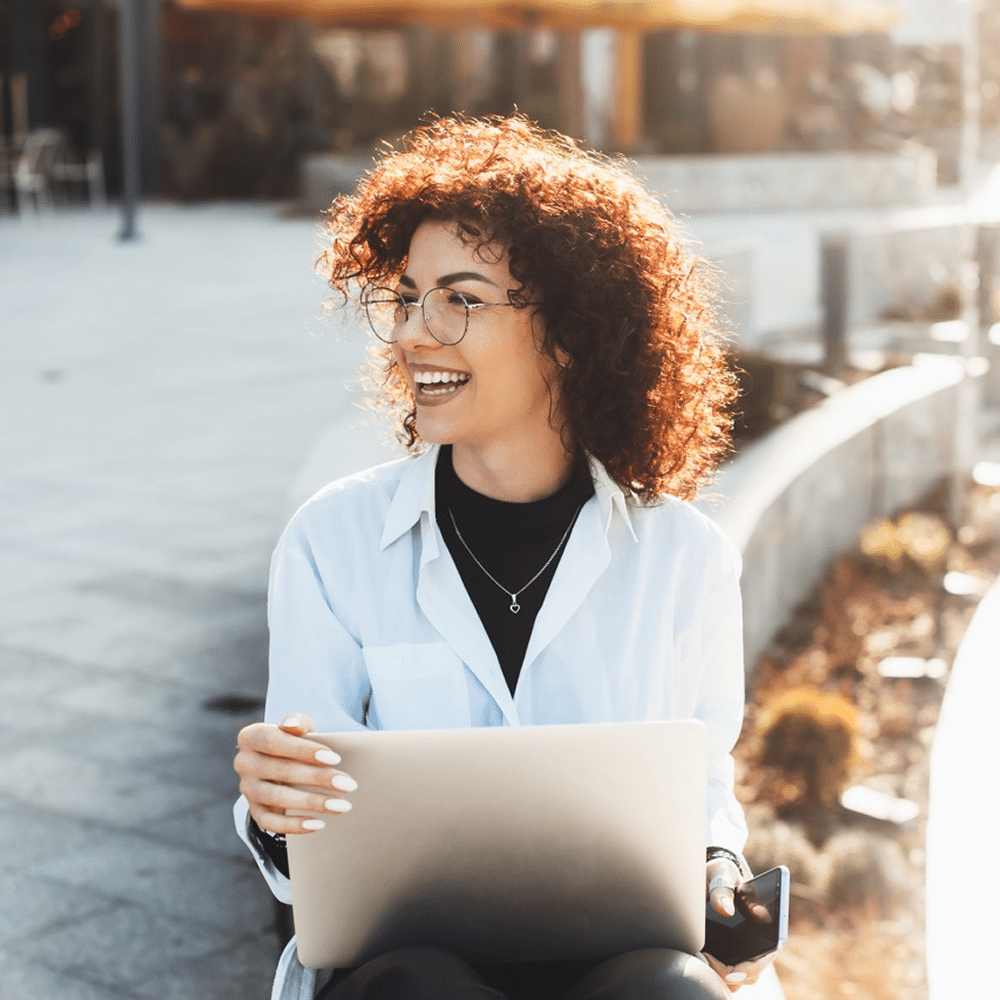 Person outdoors holding a laptop