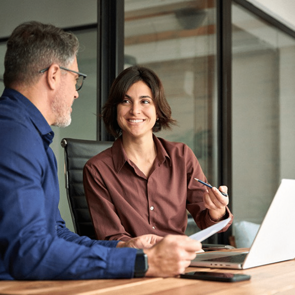 Colleagues discussing documents at a meeting table