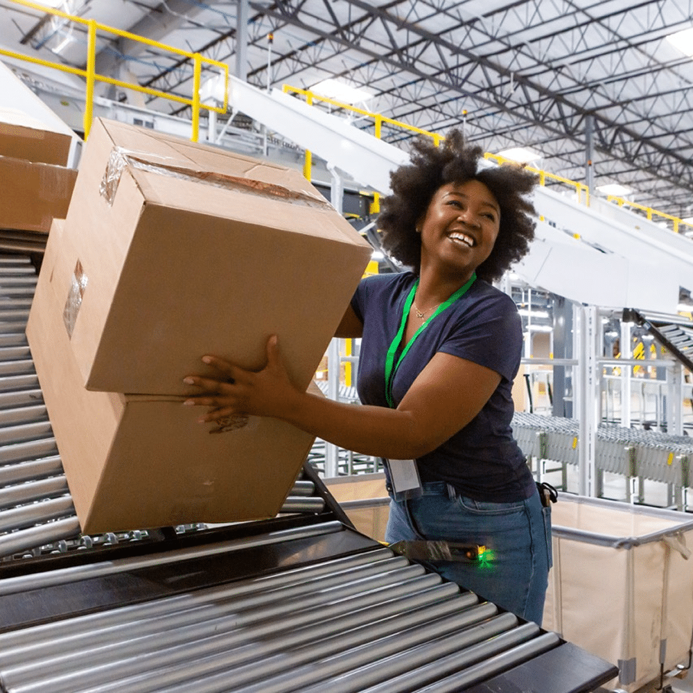 Smiling Black woman handling packages.